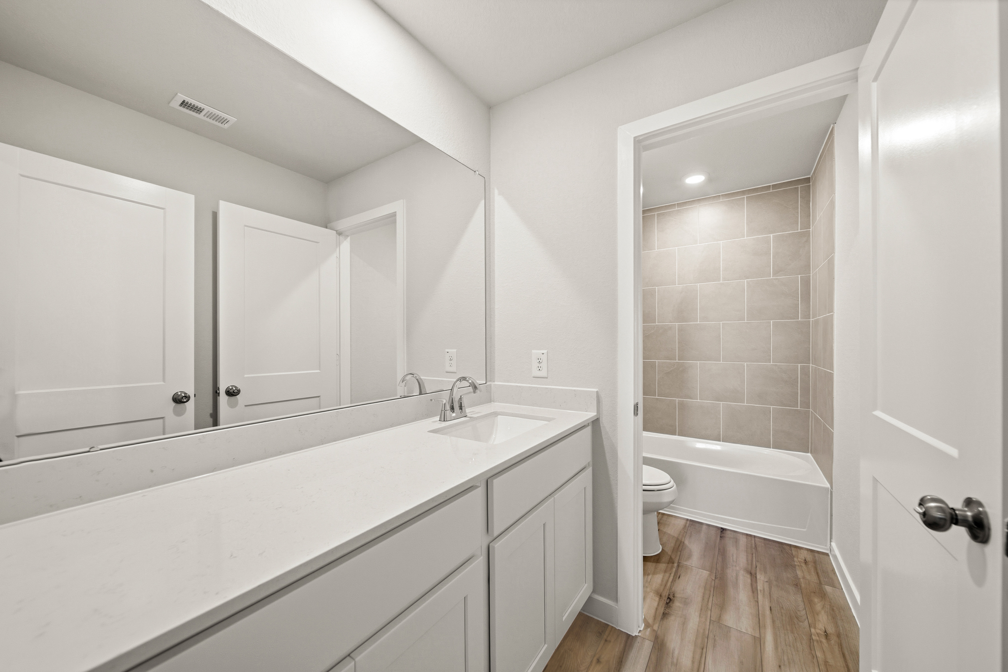 A bathroom with a tub sink and toilet.