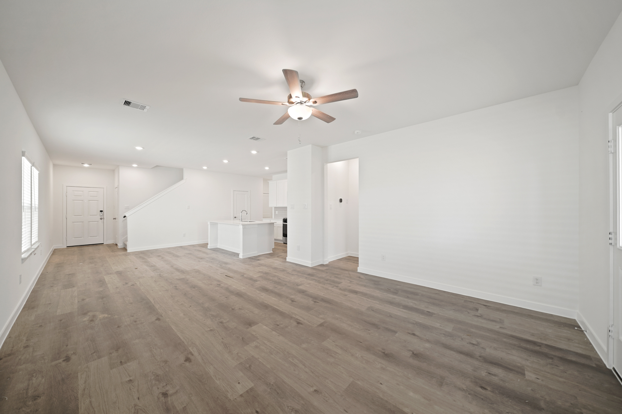 A room with a wood floor and a ceiling fan.