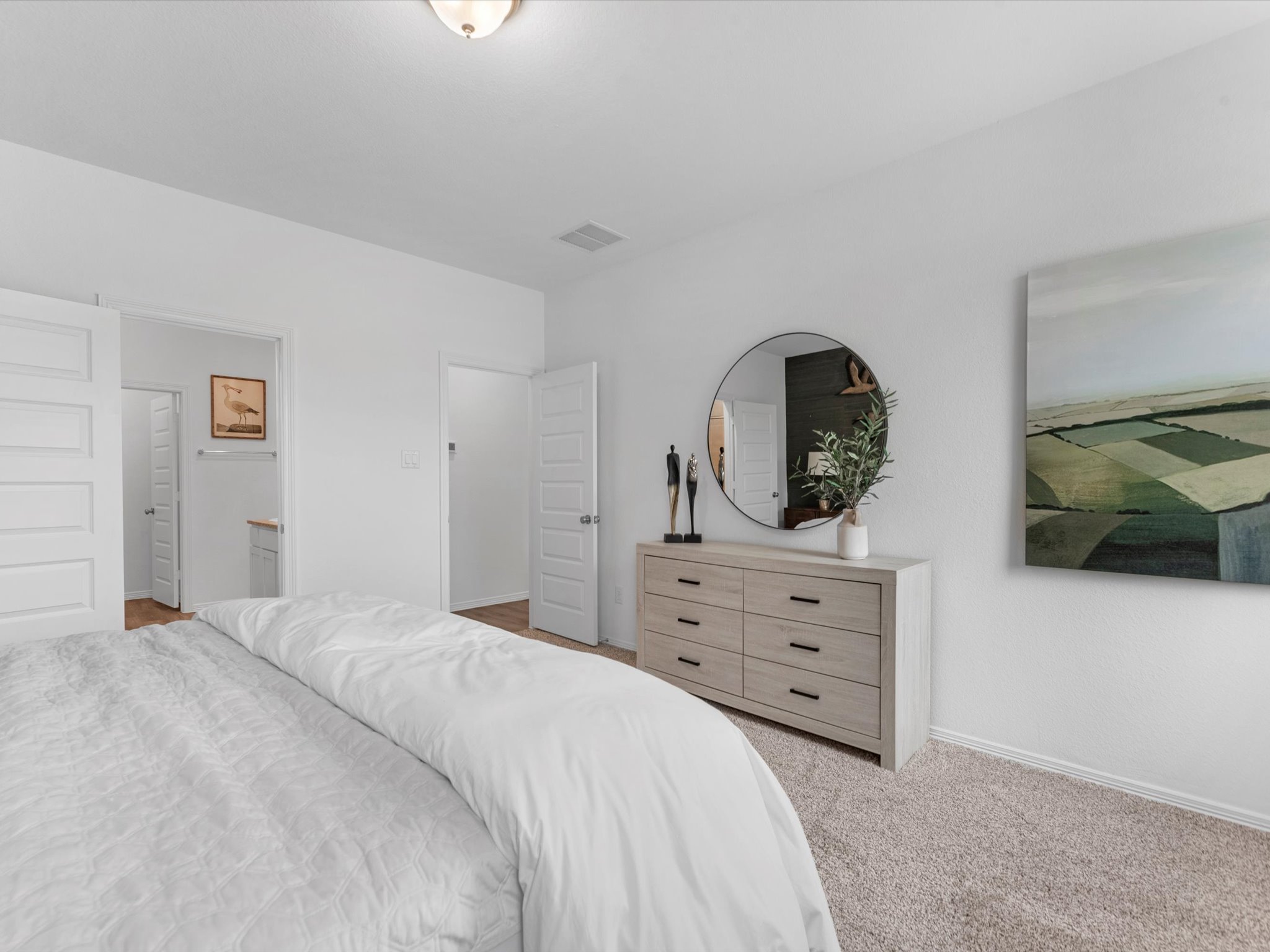 A bedroom with a large mirror.