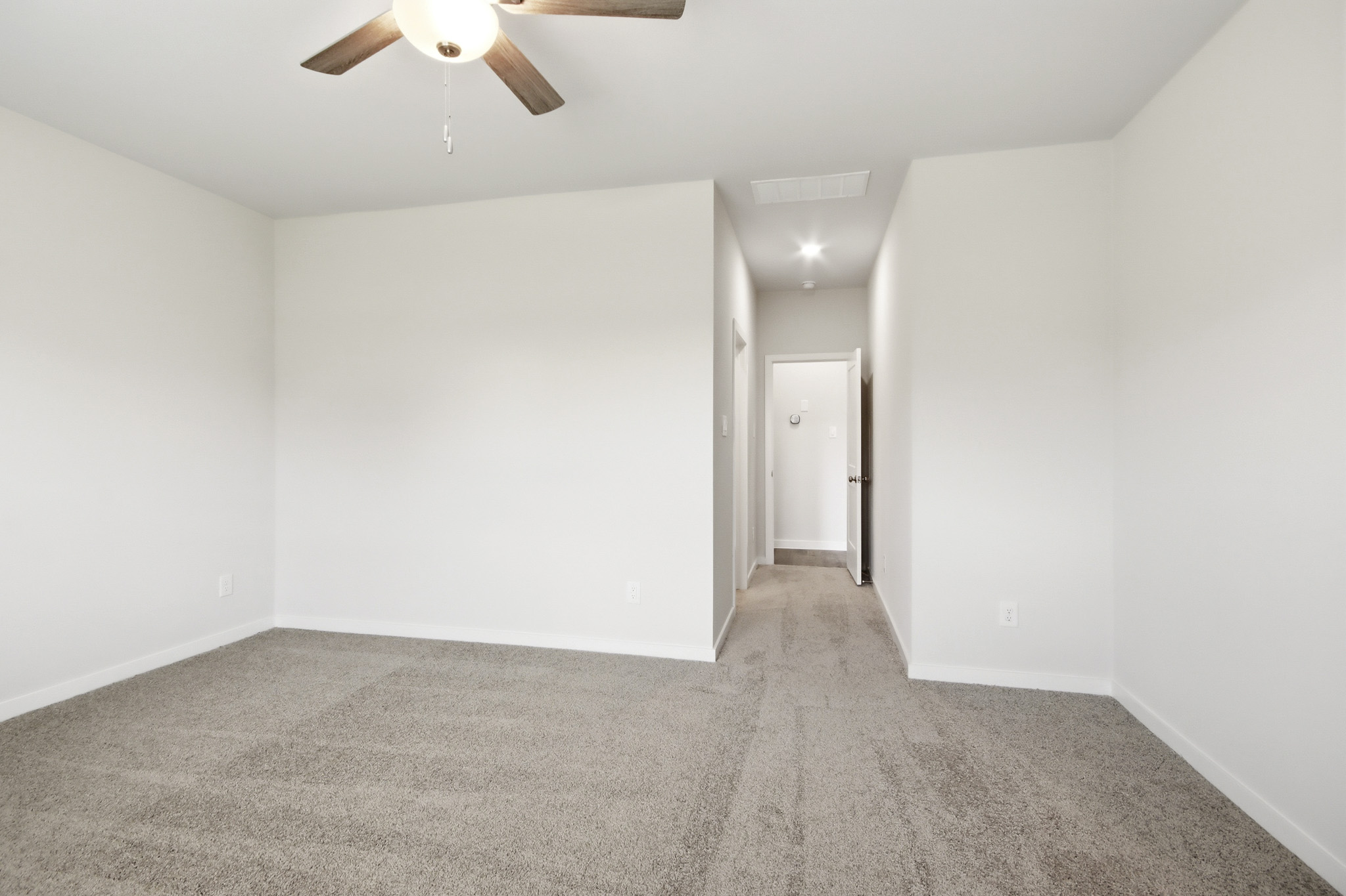 A room with a ceiling fan and a door.
