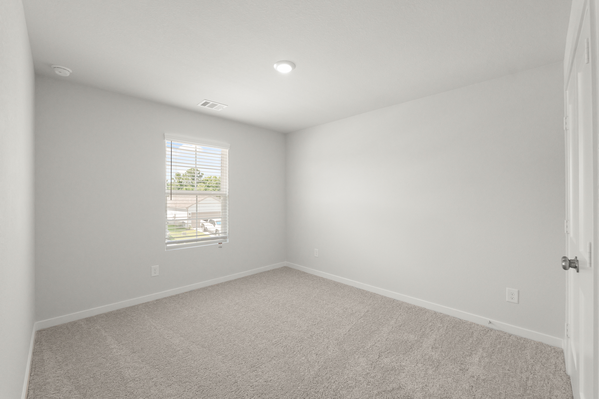 A room with a window and a carpet.