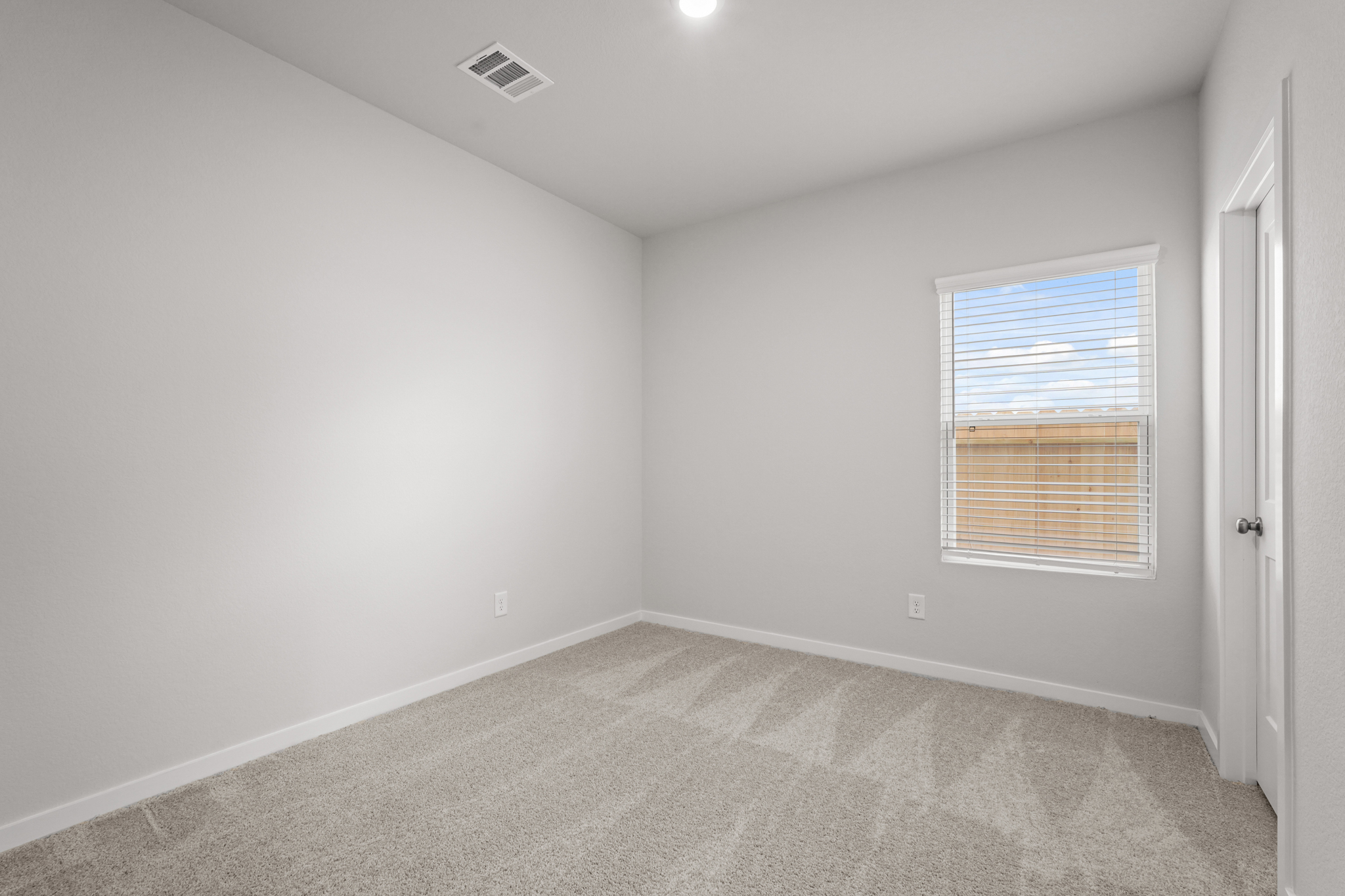 A room with a carpet and a window.