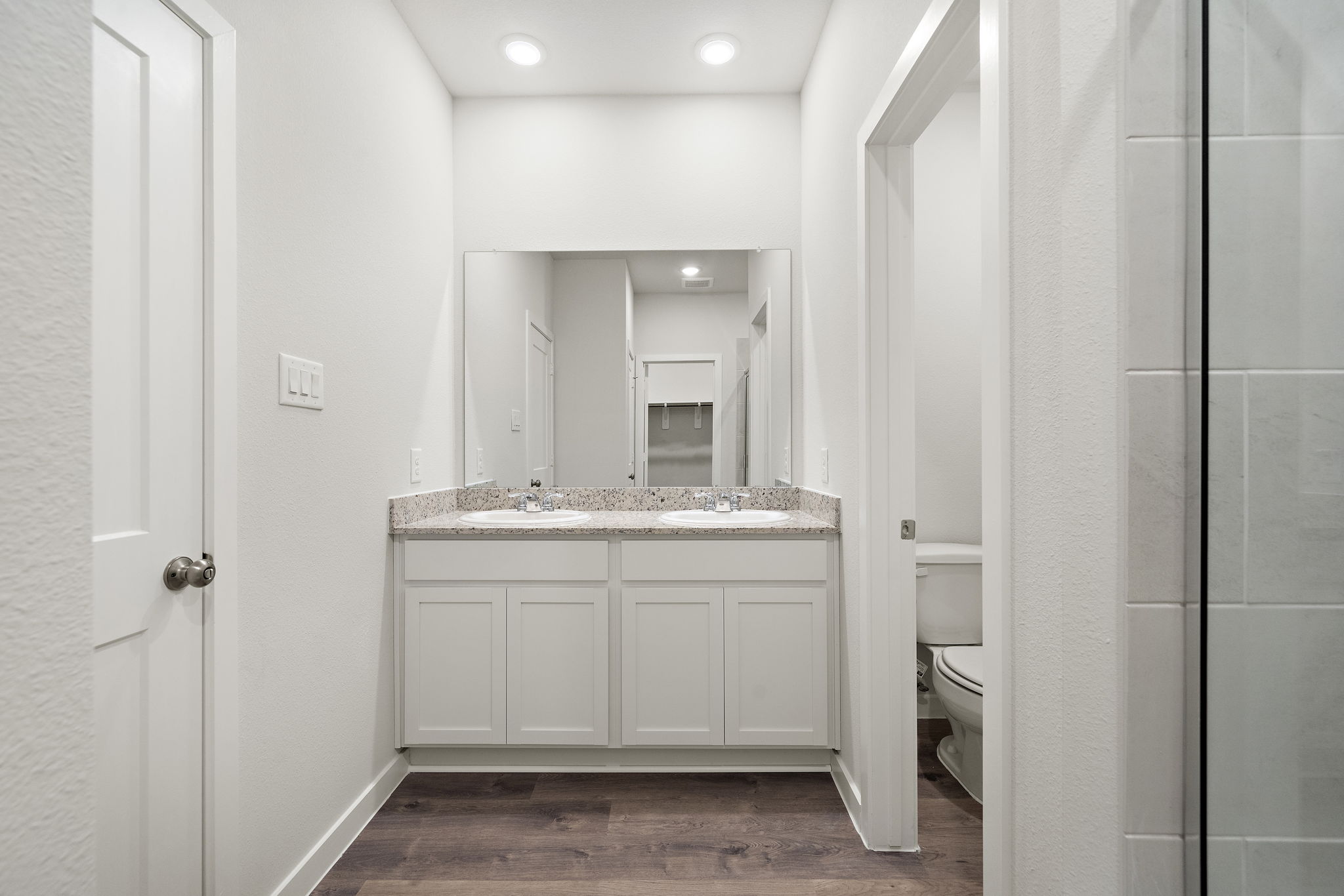 A bathroom with white cabinets.