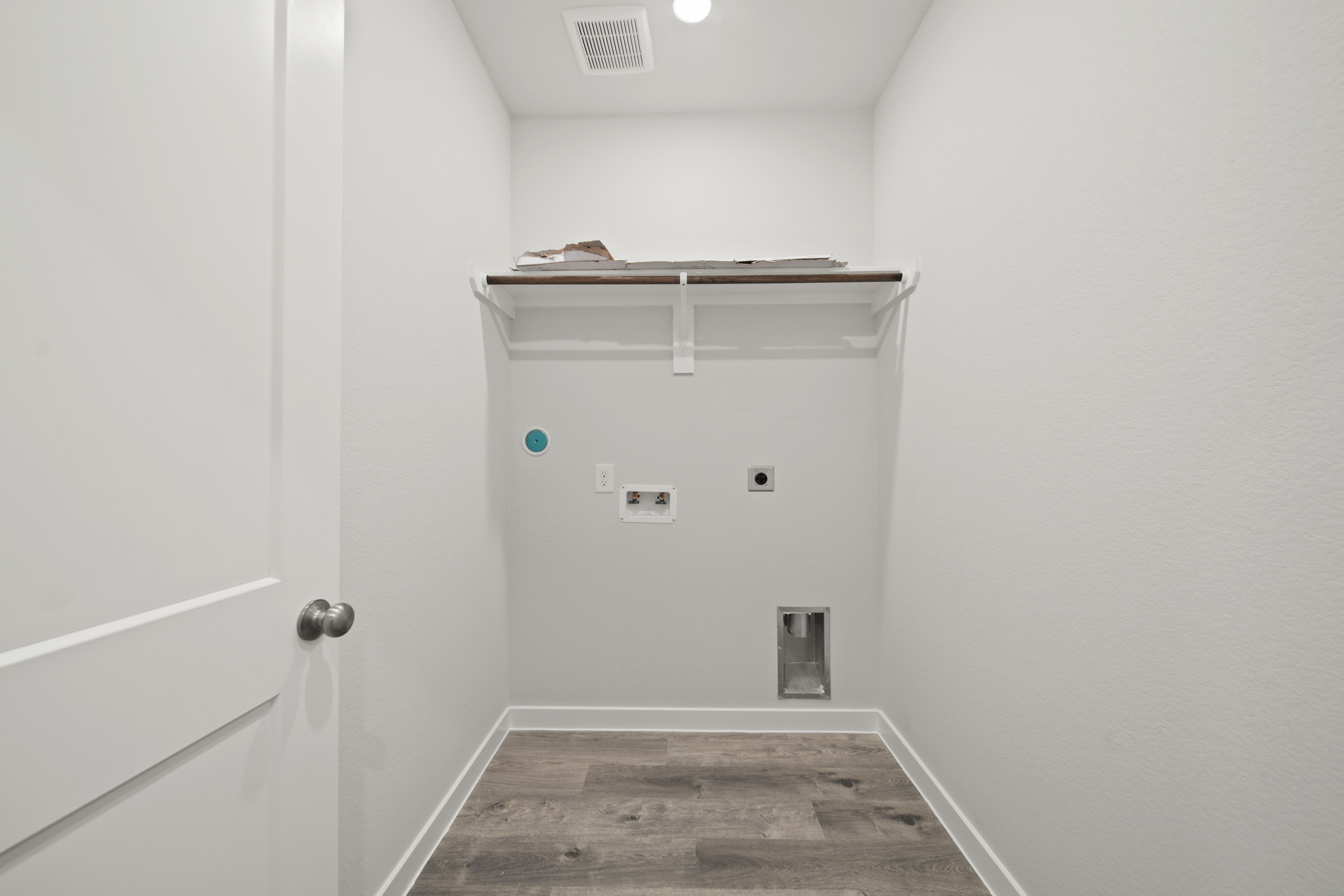 A room with a door and a shelf with a light on it.