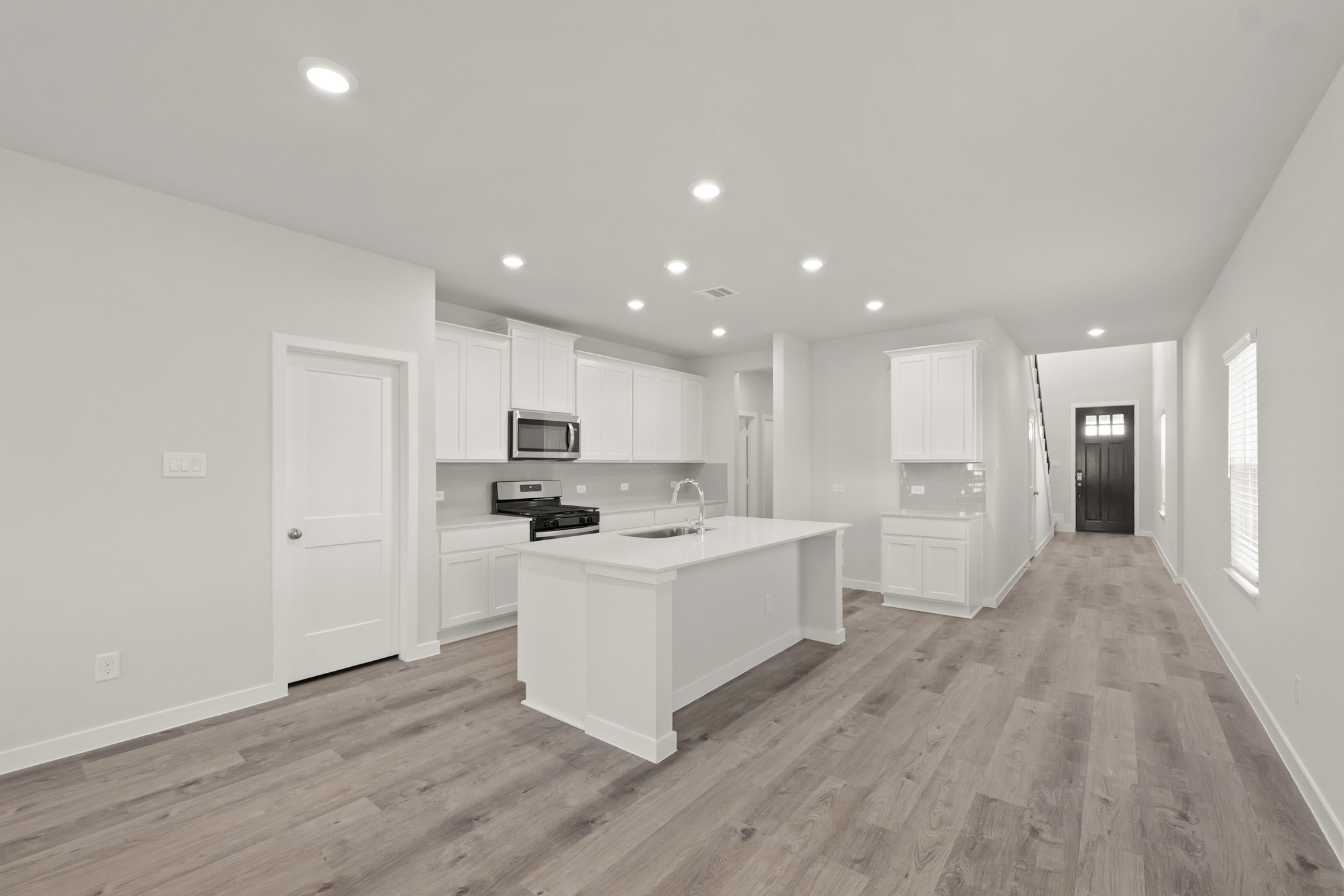 A kitchen with white cabinets.