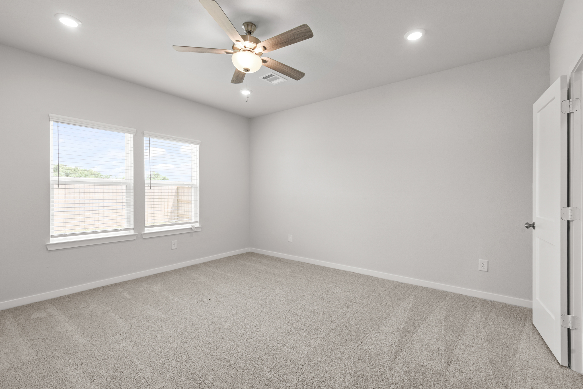 A room with a ceiling fan and a window.