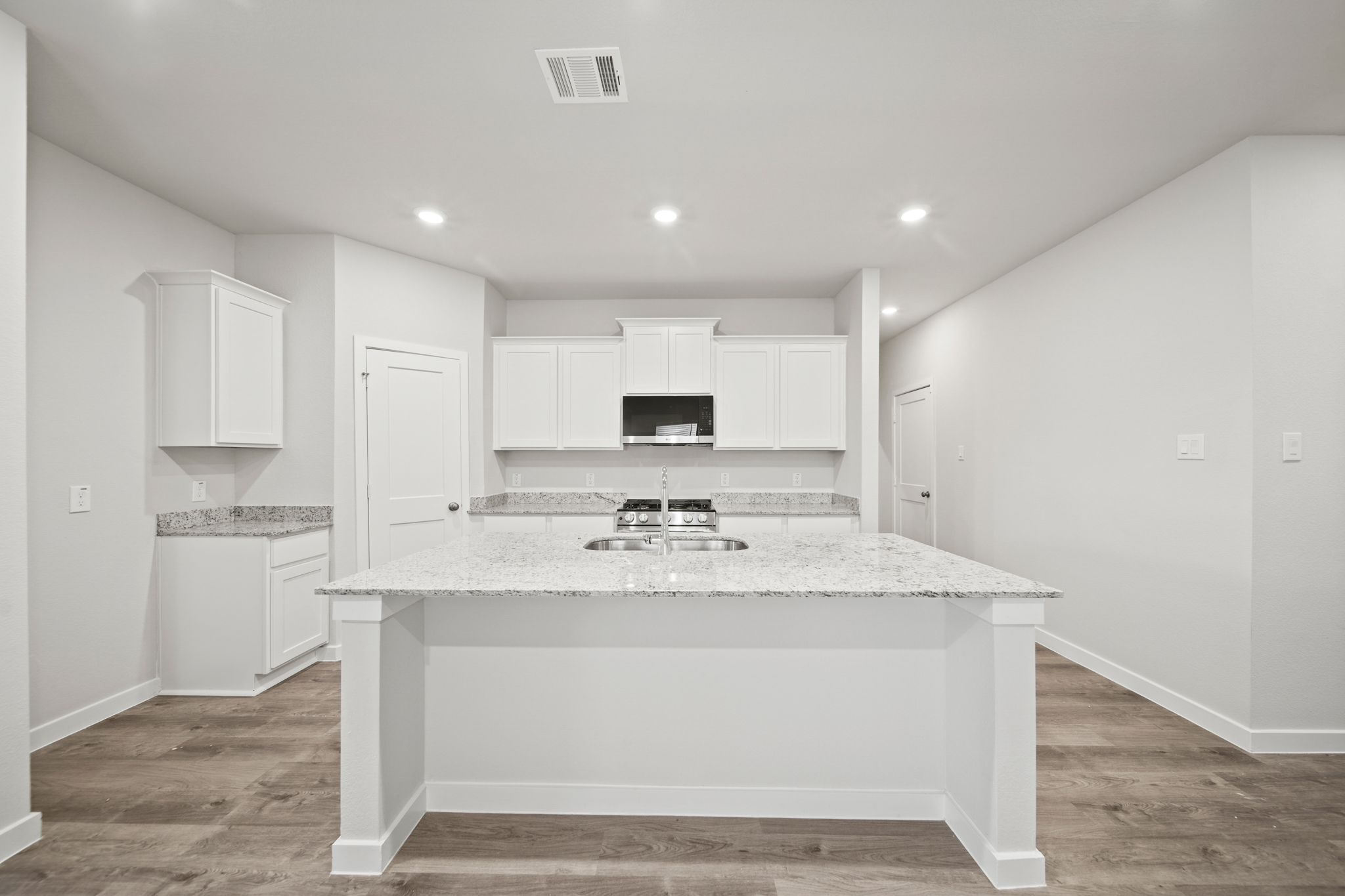 A kitchen with white cabinets.