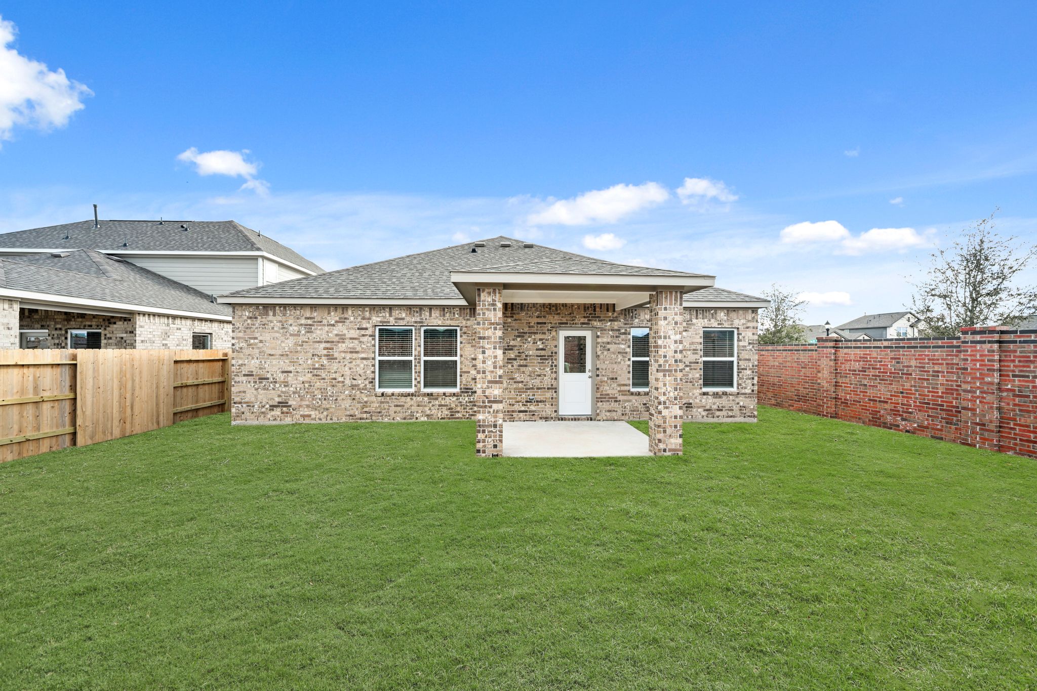 A brick house with a green lawn.