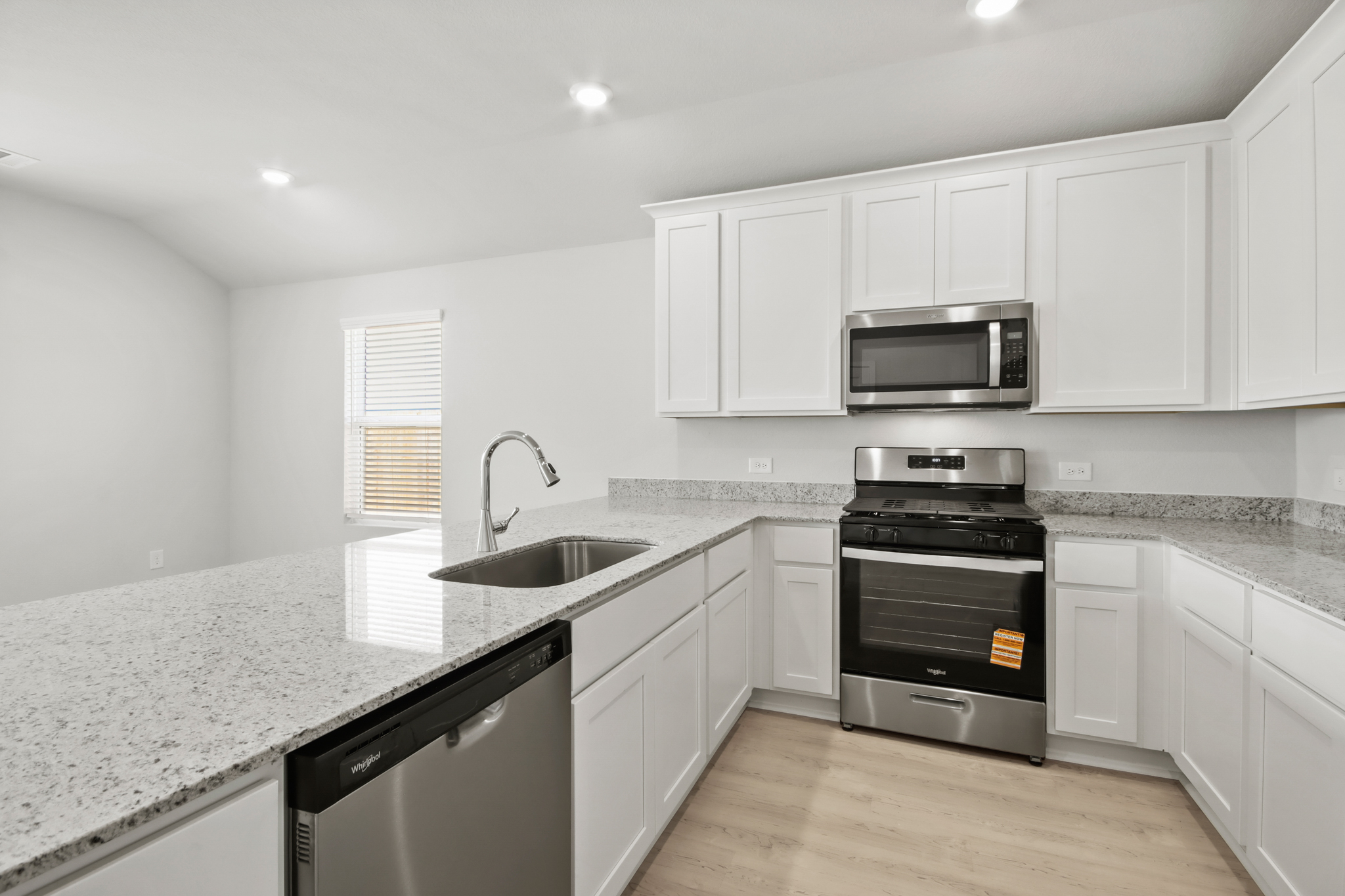 A kitchen with white cabinets.