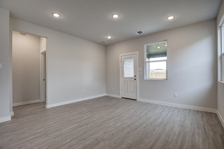 A room with a wood floor and a wood floor with a window.