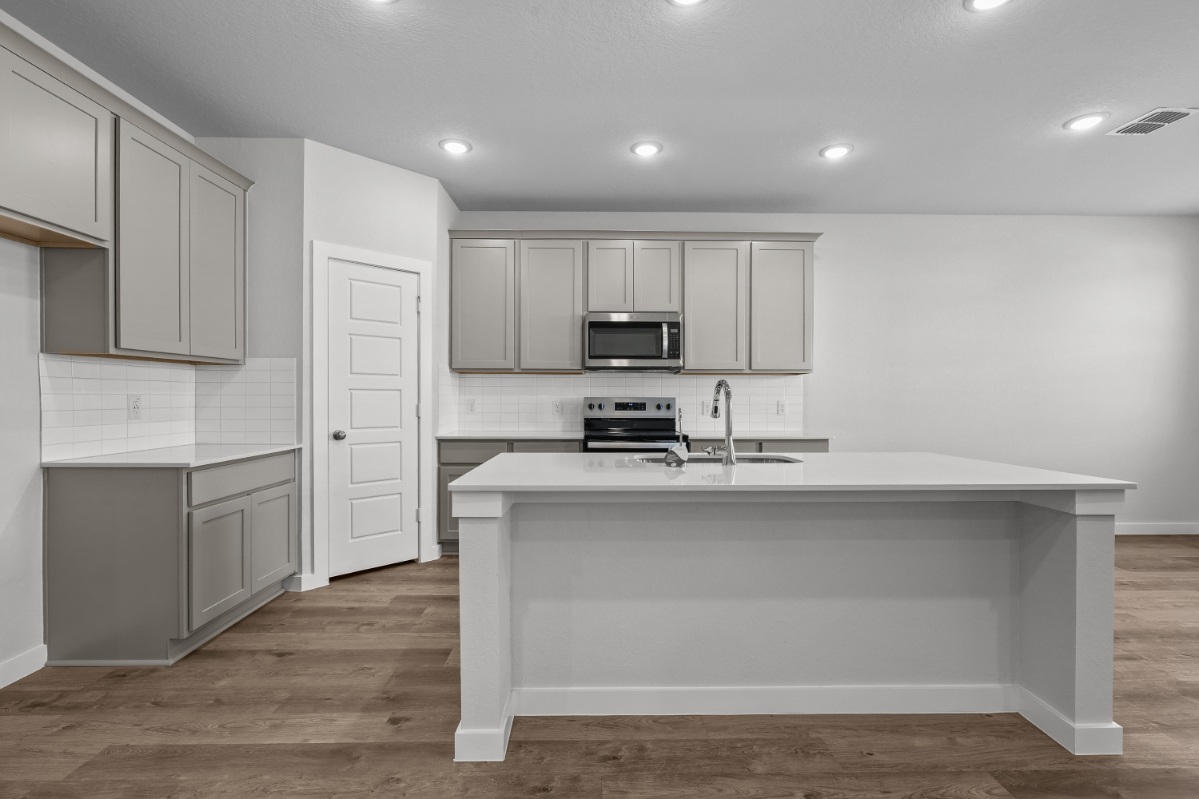 A kitchen with white cabinets.