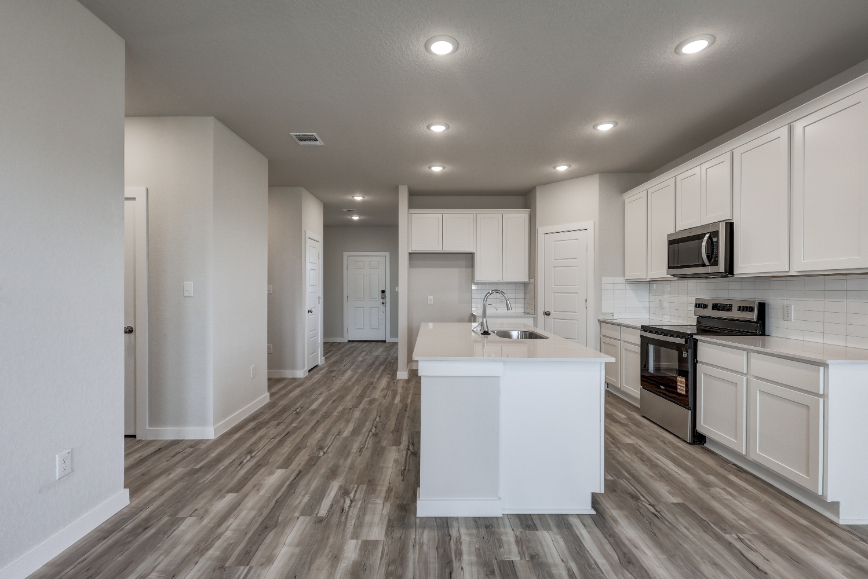 A kitchen with white cabinets.