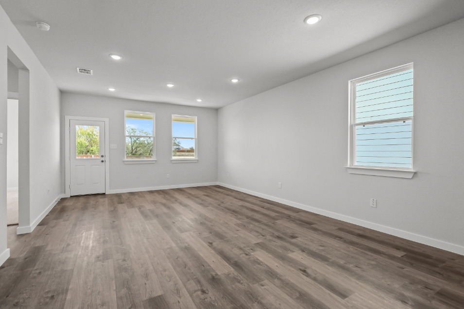 A room with windows and wood floors.