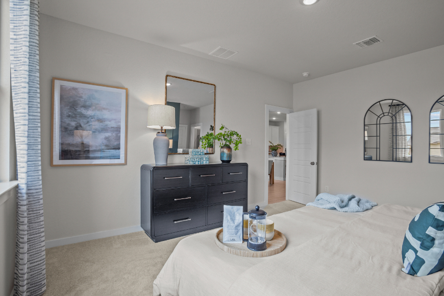 A bedroom with a bed and dresser.