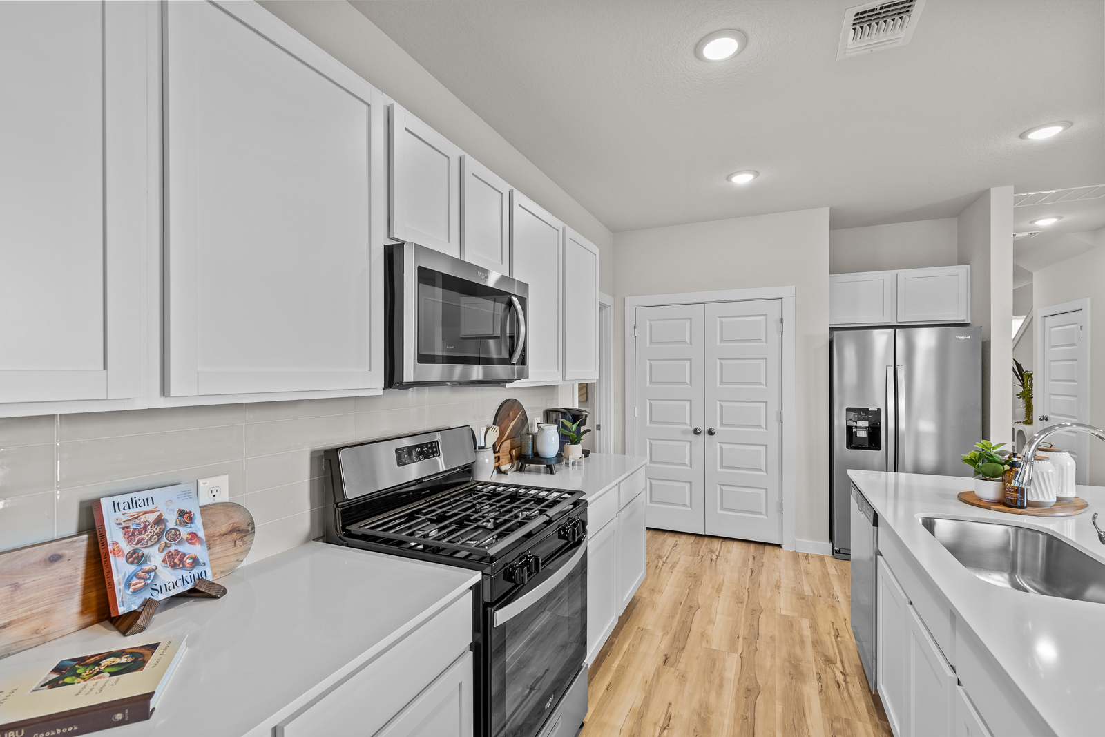 A kitchen with white cabinets.
