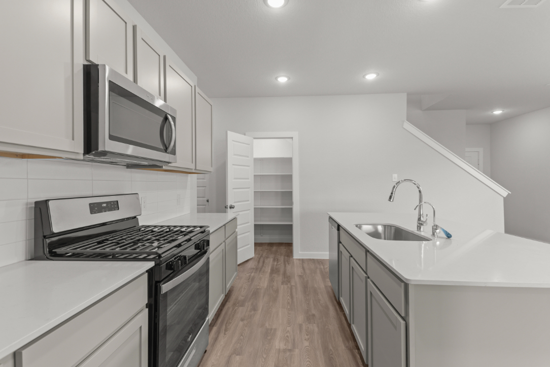 A kitchen with white cabinets.