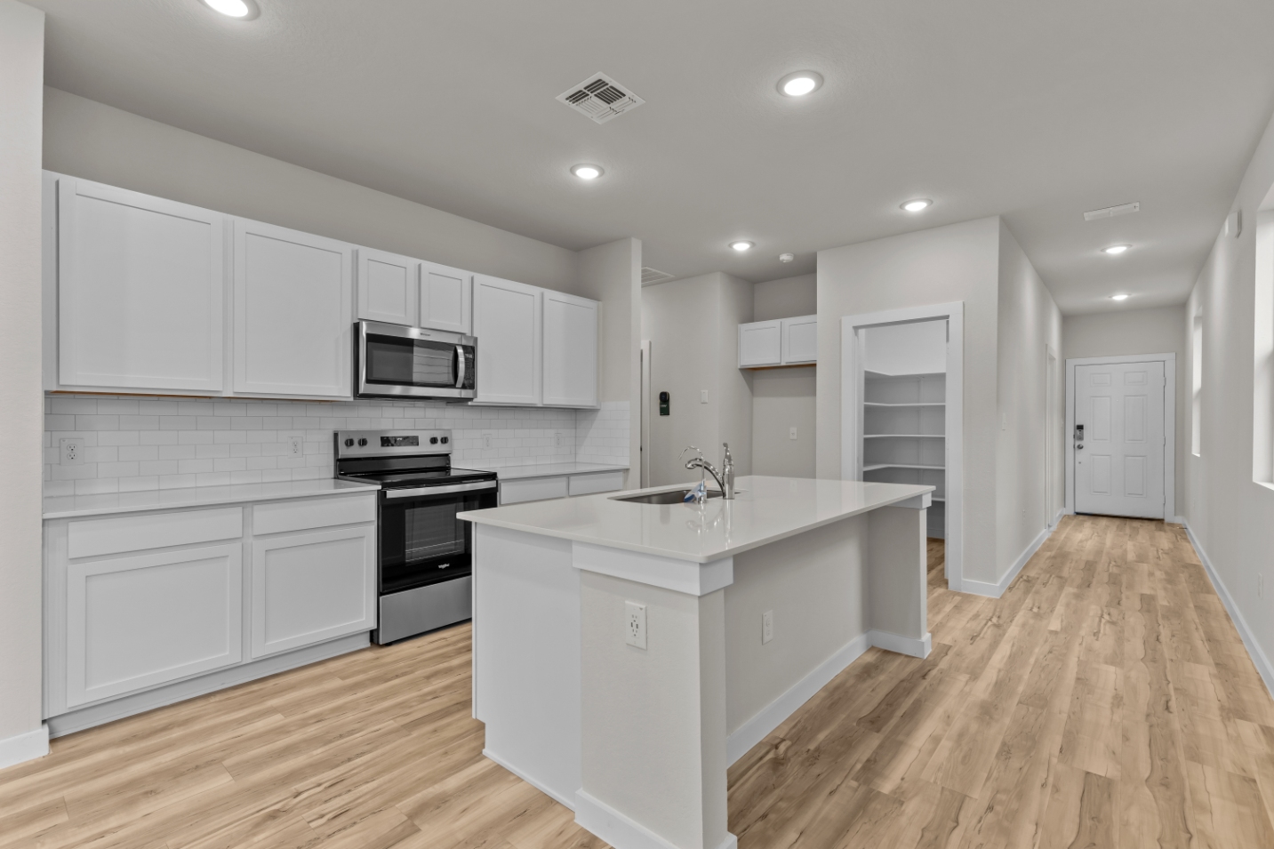 A kitchen with white cabinets.