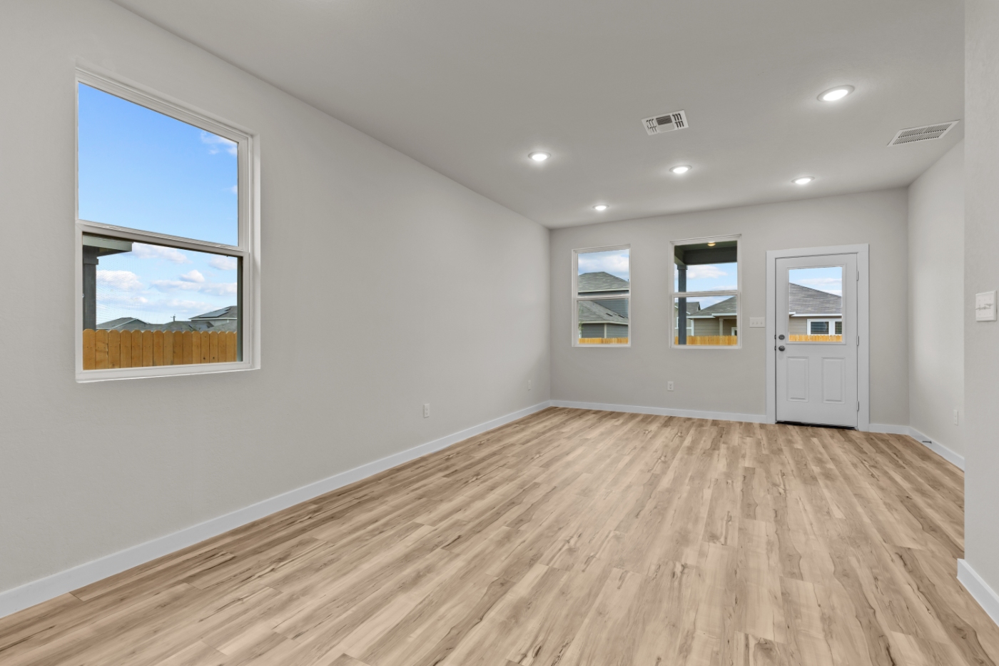 A room with a wood floor and a window with a view of the ocean.