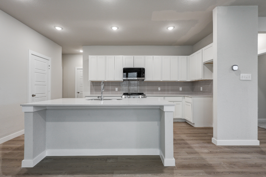 A kitchen with white cabinets.