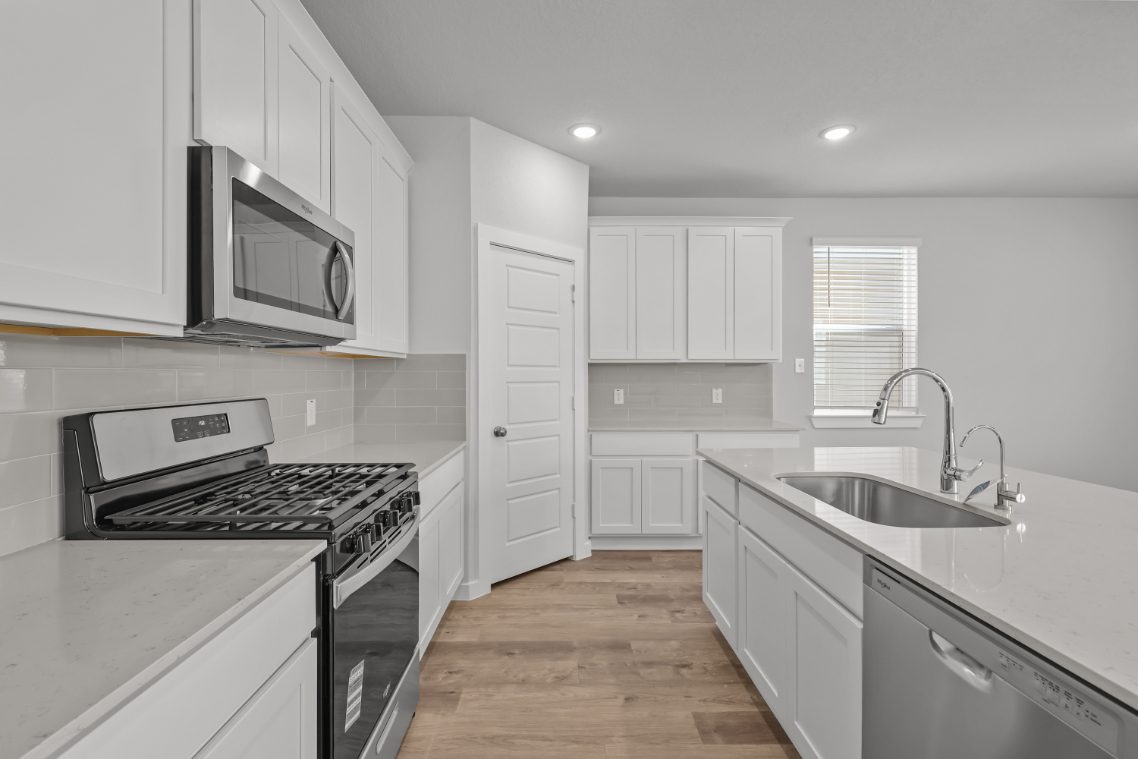 A kitchen with white cabinets.