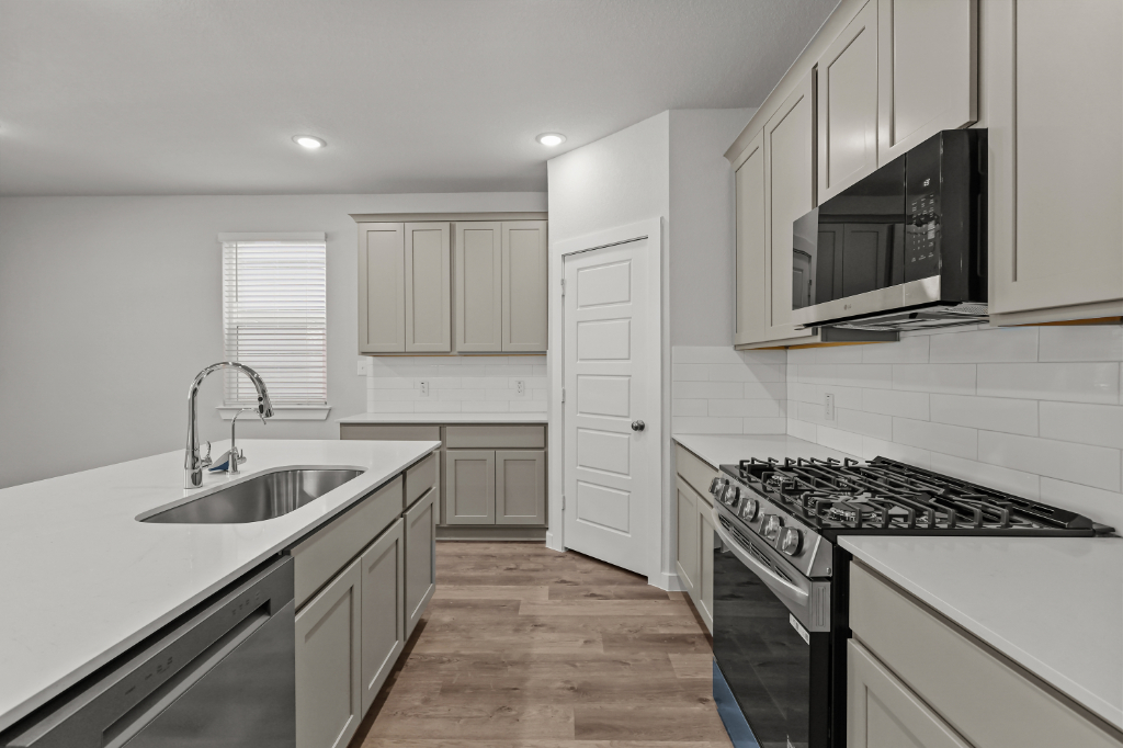 A kitchen with white cabinets.