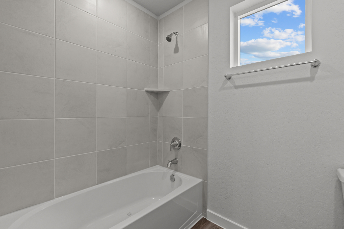 A bathroom with a tub and a window.