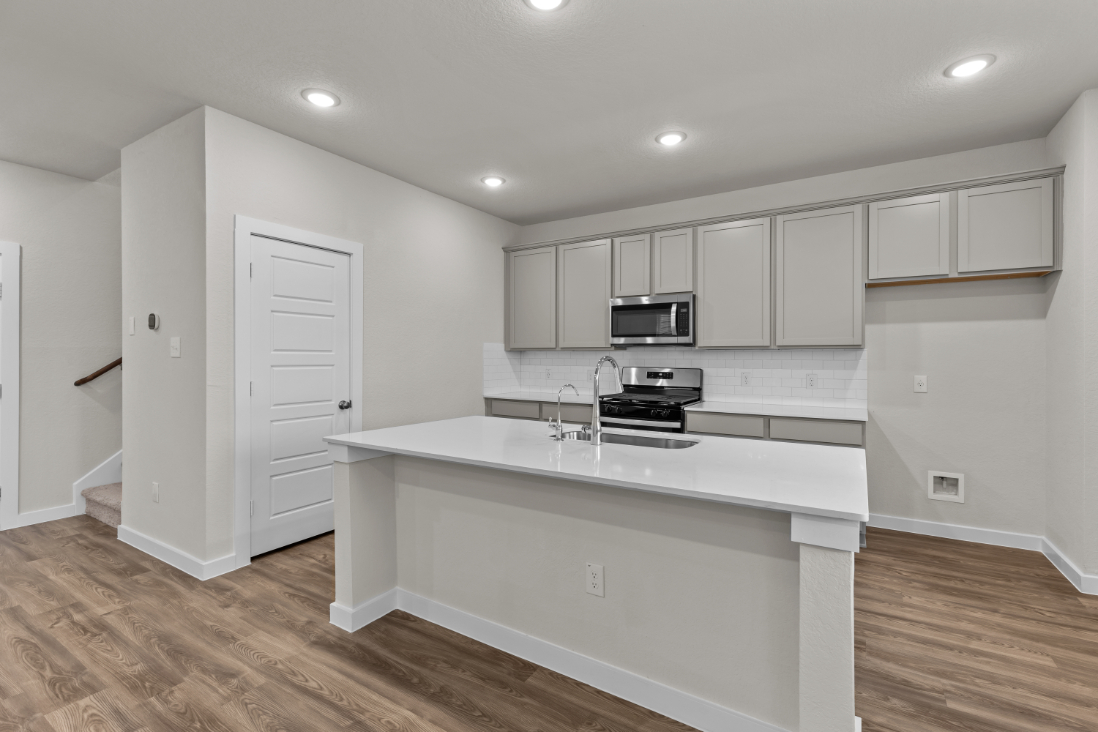 A kitchen with white cabinets.