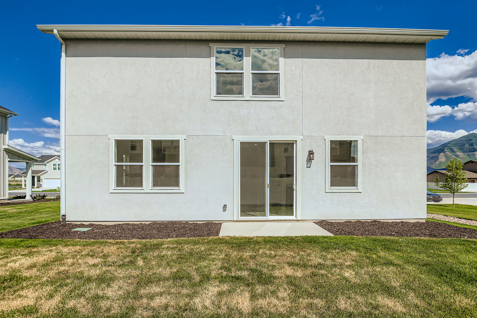 A white house with a grass yard.