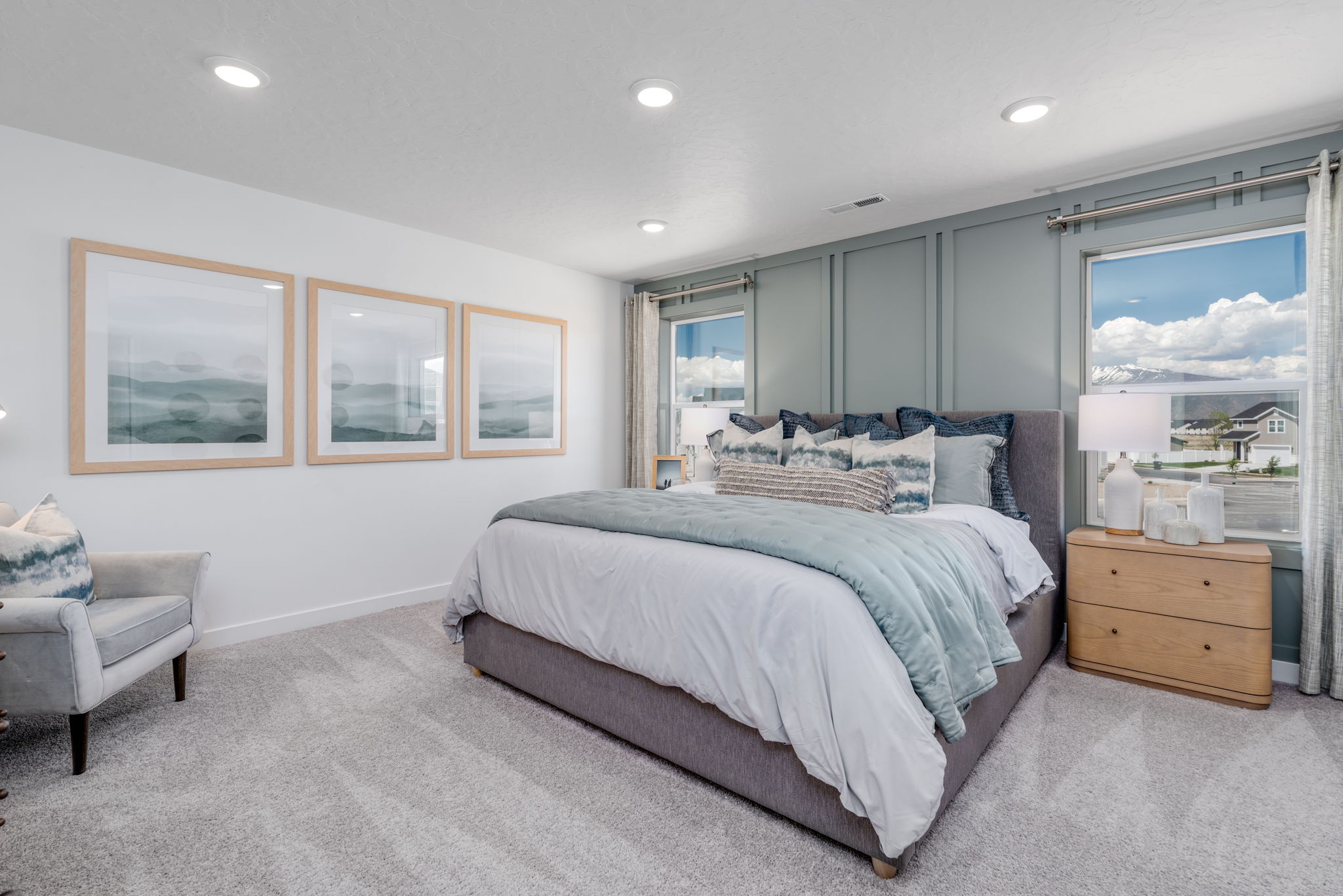 A bedroom with a bed and a chair.