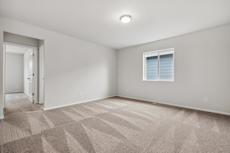 A room with a carpet and a window.