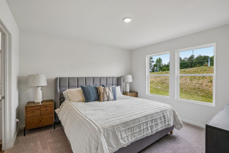 A bedroom with a large window.