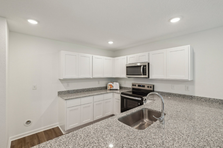 A kitchen with white cabinets.