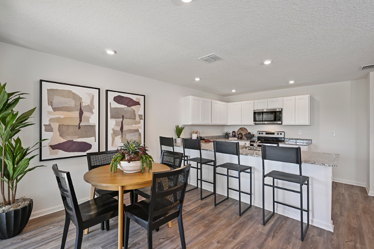 A kitchen with a dining table and chairs.