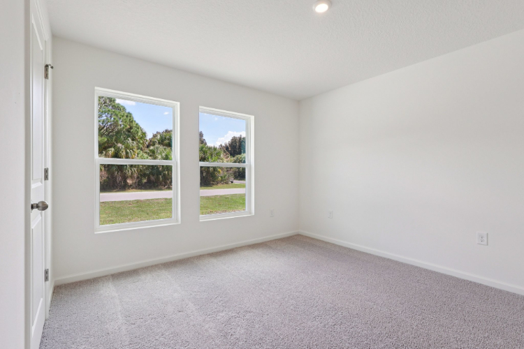 A room with a window and a door with a view of the trees.