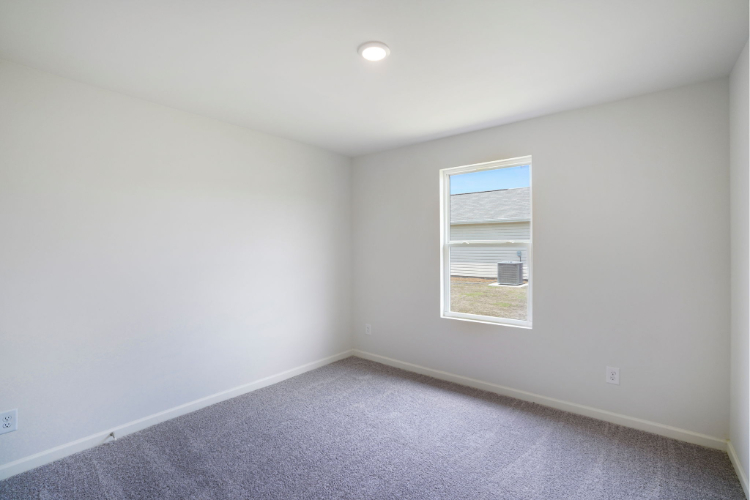 A room with a window and carpet.