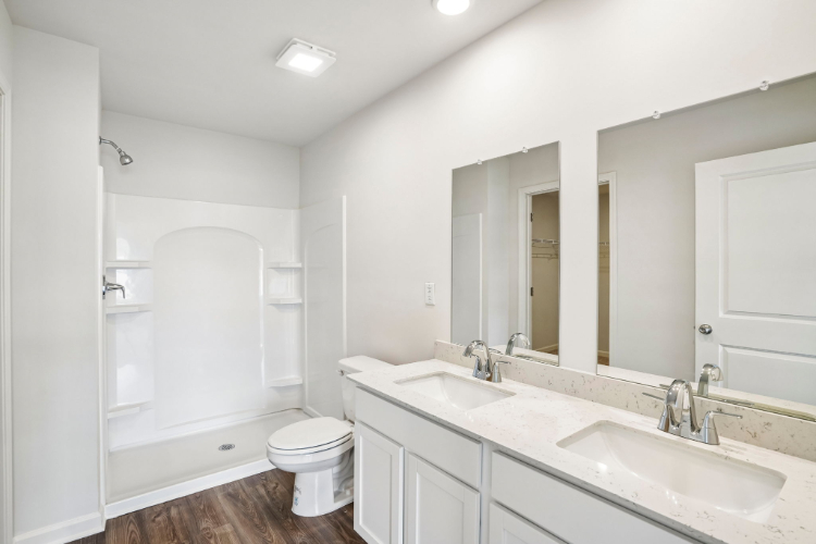 A bathroom with a toilet sink and mirror.