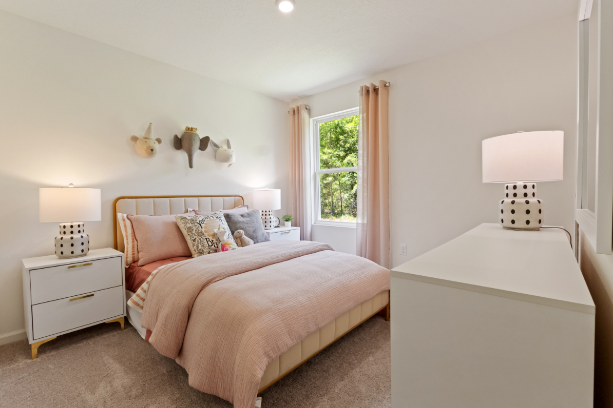 A bedroom with a bed and lamps.