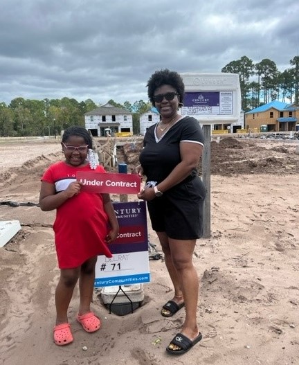 A woman holding a sign next to a man holding a sign.