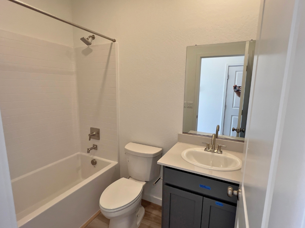 A bathroom with a sink toilet and bathtub.
